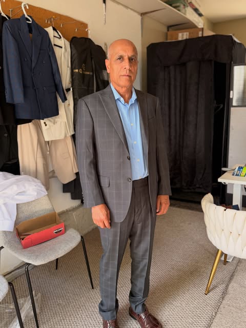 Client in a grey custom suit inside the showroom
