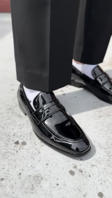 Black patent leather loafers with black tailored trousers
